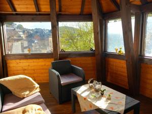 een kamer met een tafel, stoelen en ramen bij Hotel Schloßschenke in Idar-Oberstein