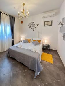 a bedroom with a large bed and a chandelier at MUSTRA House Zadar - Private Pool & Sauna in Zadar
