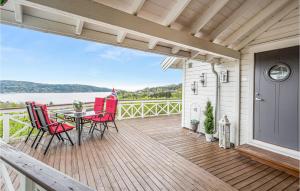 eine Terrasse mit einem Tisch und Stühlen auf einer Terrasse in der Unterkunft Gorgeous Home In Berger With House Sea View in Svelvik