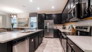 a kitchen with black cabinets and a stainless steel refrigerator at 8972 Amelia Downs in Orlando