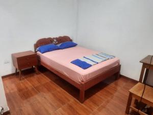 ein kleines Bett in einem Zimmer mit Holzboden in der Unterkunft Casa Grande in Iquitos