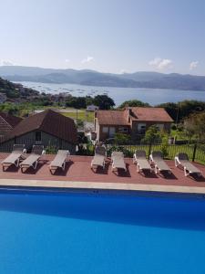 a row of lounge chairs next to a swimming pool at Apartamentos Canada 1 in Raxó