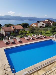 a swimming pool with chairs and a view of the water at Apartamentos Canada 1 in Raxó