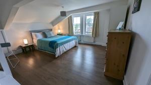a bedroom with a bed and a large window at Upstairs Downstairs Regency Apartments in Cheltenham