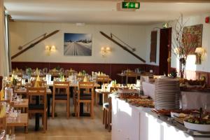 a restaurant with tables and chairs and food on a counter at Nordseter Apartments in Lillehammer