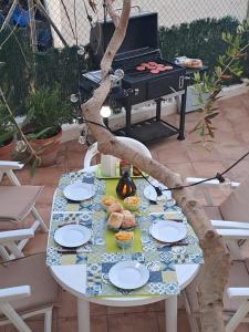 a table with plates of food and a tree at Casa apareada cerca de la playa in Torredembarra