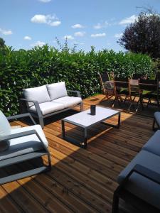 eine Terrasse mit Stühlen, einem Sofa und einem Couchtisch in der Unterkunft Grande Maison de plain pied avec jardin arboré. in Champignelles