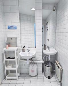 a white bathroom with two sinks and a mirror at Noclegi Wałbrzych Centrum in Wałbrzych