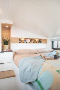 a bedroom with a large bed and a desk at Refuge Bay's Aqua Tiny Home - Luxury Off Grid Escape 