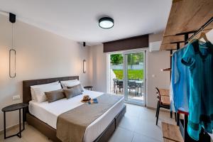 1 Schlafzimmer mit einem Bett und einem Balkon mit einem Tisch in der Unterkunft Sokrates Studios in Afandou