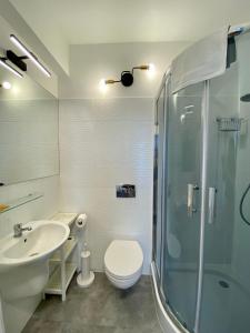ein Bad mit einer Dusche, einem WC und einem Waschbecken in der Unterkunft Apartament 215 Planeta 2-pokojowy z balkonem in Mielno