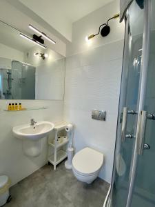 ein Bad mit einem Waschbecken, einem WC und einer Dusche in der Unterkunft Apartament 215 Planeta 2-pokojowy z balkonem in Mielno