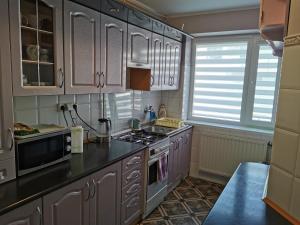 a kitchen with white cabinets and a stove top oven at Pokoje Gościnne KASZUB in Karwia