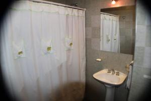 a bathroom with a sink and a white shower curtain at Pequeña Allegra in San Juan