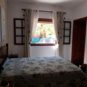 a bedroom with a large bed and a window at Casa de campo c churrasqueira e Wi-Fi Itatiba SP in Itatiba