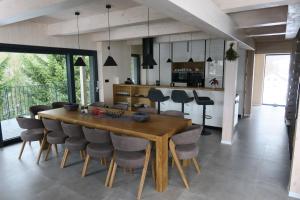 a dining room and kitchen with a wooden table and chairs at Chata Jestřábník in Dolní Morava