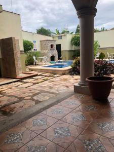 un patio con un pilar y una piscina en Mountain View Lofts Guayabitos en Rincon de Guayabitos