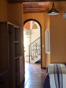 a room with a bed and a hallway with a staircase at Mountain View Lofts Guayabitos in Rincon de Guayabitos