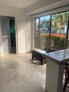 a room with a table and a bench in a building at Amazing Home Ricaurte-Casa verano piscina-Aire acondicionado in Ricaurte