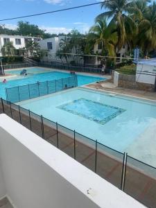 una gran piscina con 2 personas. en Amazing Home Ricaurte-Casa verano piscina-Aire acondicionado en Ricaurte