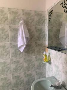 een badkamer met een wastafel en een handdoek aan de muur bij Amazing Home Ricaurte-Casa verano piscina-Aire acondicionado in Ricaurte