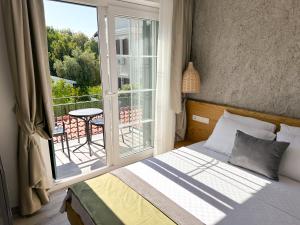 a bedroom with a bed and a large window at Müzeyyen Hanım Konağı Alaçatı in Alacati