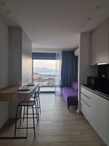 a kitchen and living room with a purple couch at MA Apartments in Senj