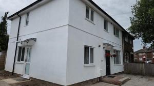 a white house with a black door and windows at White House Ensuite double bedroom in Warrington