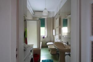 a bathroom with two toilets and a sink and mirrors at Casailaekobe in Bologna