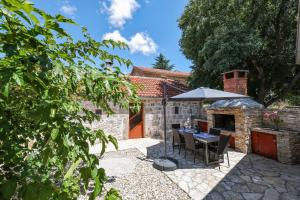 a patio with a table and an umbrella at Holiday house Manuela in Kruševo