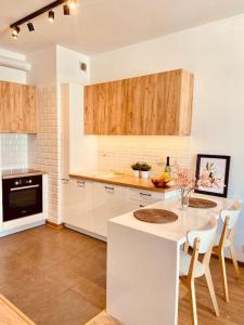 a kitchen with white cabinets and a table with chairs at Spacious,Stylish and Comfortable 2 room apartment with Million dollar view in Warsaw