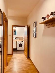 a hallway leading to a kitchen with a washing machine at Spacious,Stylish and Comfortable 2 room apartment with Million dollar view in Warsaw