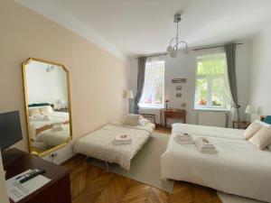 1 Schlafzimmer mit 2 Betten und einem großen Spiegel in der Unterkunft Magic Vienna right next to the Prater! in Wien