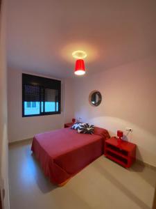 een slaapkamer met een rood bed en een rode tafel bij Apartament Las Olas Cambrils in Cambrils