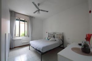 a white bedroom with a bed and a window at Casailaekobe in Bologna