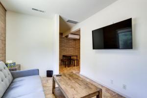 een woonkamer met een bank en een flatscreen-tv bij Clear Lake Getaway with Pool Access, Near Beaches! in Clearlake Oaks