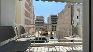 balcón con sillas y vistas a la ciudad en Alfa home en Atenas