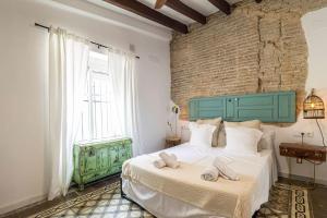 Schlafzimmer mit einem großen Bett mit einem grünen Kopfteil in der Unterkunft Kala Ático - Apartamento Centro Jerez in Jerez de la Frontera