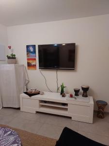 a living room with a flat screen tv on a wall at Dudger apartment in Bet Shemuʼel