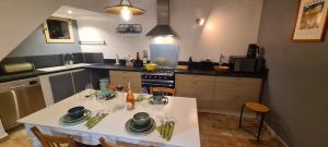 una cocina con una mesa con platos y copas de vino en Cocon du Papillon à Lourmarin, en Lourmarin