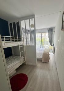 a bedroom with two bunk beds and a window at Appartement terrasse privée grande plage à 100 m - Parking gratuit in Saint-Cast-le-Guildo