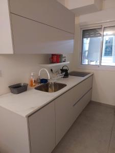 a white kitchen with a sink and a window at Dudger apartment 