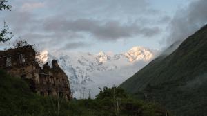 une montagne avec des montagnes enneigées au loin dans l'établissement Gaul Gavkhe Hotel, à Ushguli