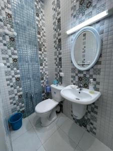 ein Badezimmer mit einem WC, einem Waschbecken und einem Spiegel in der Unterkunft Kelibia in Kelibia