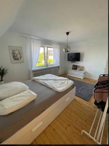 Schlafzimmer mit einem großen Bett und einem Fenster in der Unterkunft Geräumige Wohnfühloase mit 3 Schlafzimmern in Garbsen