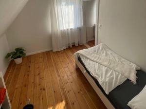 Schlafzimmer mit einem Bett und Holzboden in der Unterkunft Geräumige Wohnfühloase mit 3 Schlafzimmern in Garbsen