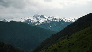 una montaña cubierta de nieve en medio de un valle en Gaul Gavkhe Hotel en Ushguli