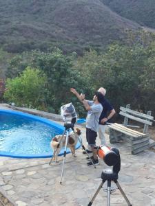 two people and a dog near a swimming pool at Cabañas Ocoa in Hijuelas