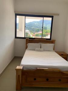 łóżko w pokoju z dużym oknem w obiekcie Hotel Hacienda Guane Urbano w mieście Oiba