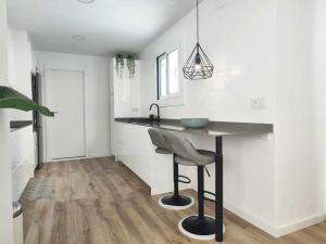 a kitchen with a table and a chair in a room at Mazi Apartments Cuba in Mataró +20 photos